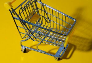 stainless steel shopping cart on yellow background