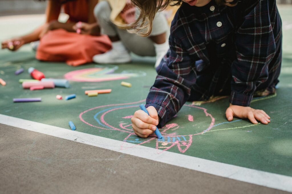 a girl drawing with colored chalk